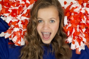 Excited cute teenage cheerleader smiling with braces